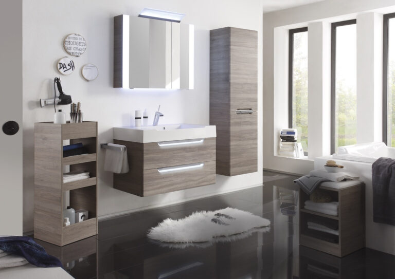Modernes Badezimmer mit schwebendem Waschtisch, beleuchtetem Spiegel und Stauraum.