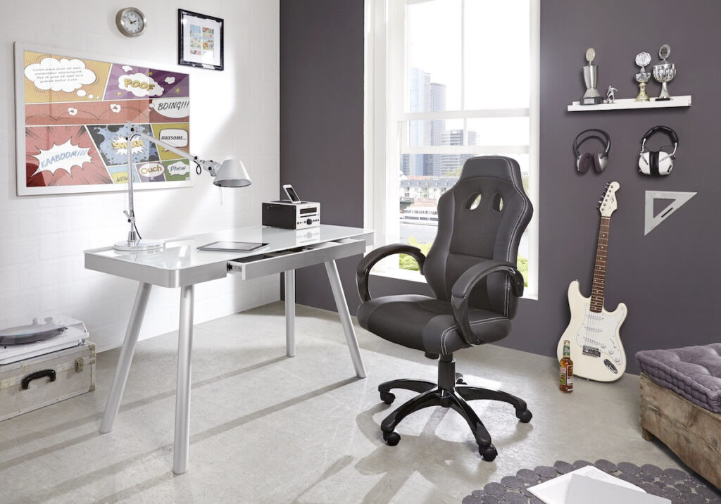 Moderner Glasschreibtisch mit silbernen Beinen, schwarzer Gaming-Stuhl und Gitarre in einem stilvollen Home-Office.