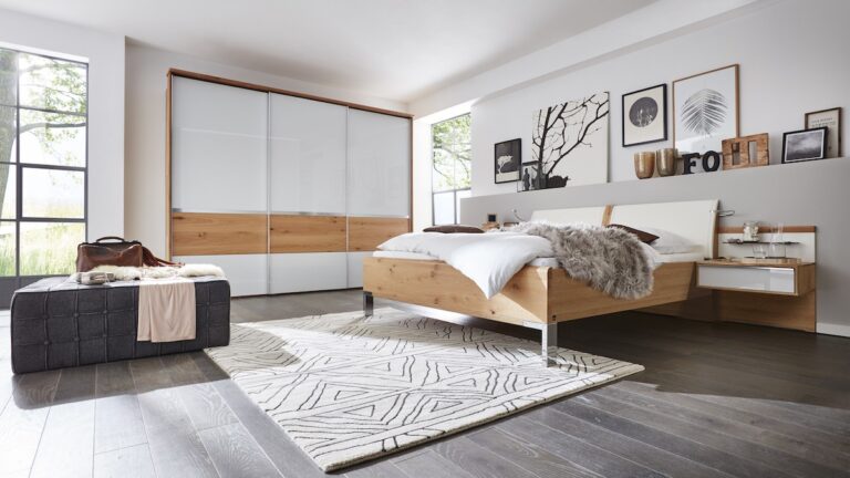 Schlafzimmer mit großem Kleiderschrank in Weiß und einem Doppelbett aus Holz