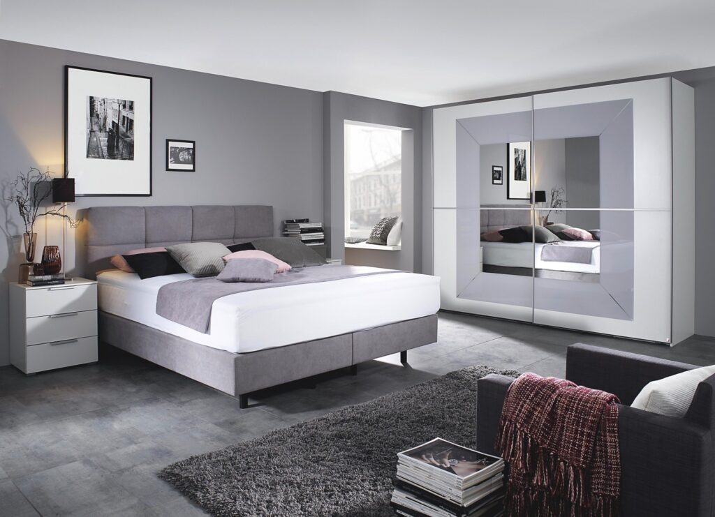Modernes graues Schlafzimmer mit Polsterbett und Spiegelschrank sowie einem grauen Teppich
