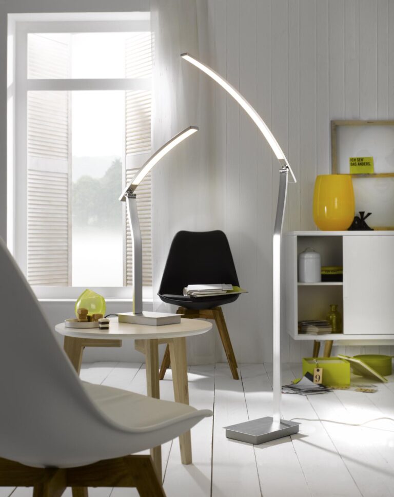 Moderne Bogen-Steh- und Tischleuchten erhellen ein Wohnzimmer.