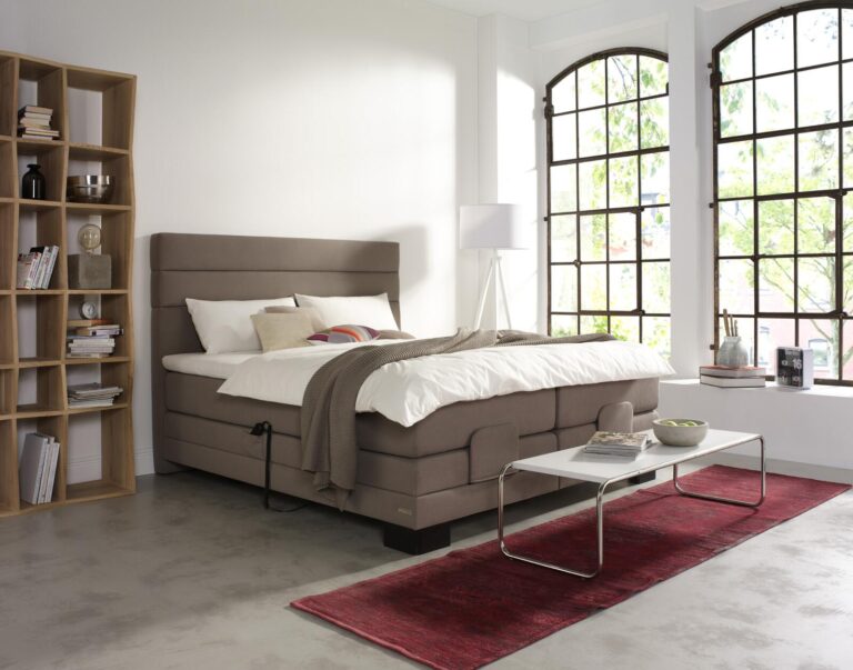 Modernes verstellbares Bett mit weißer Bettwäsche in einem hellen Schlafzimmer.