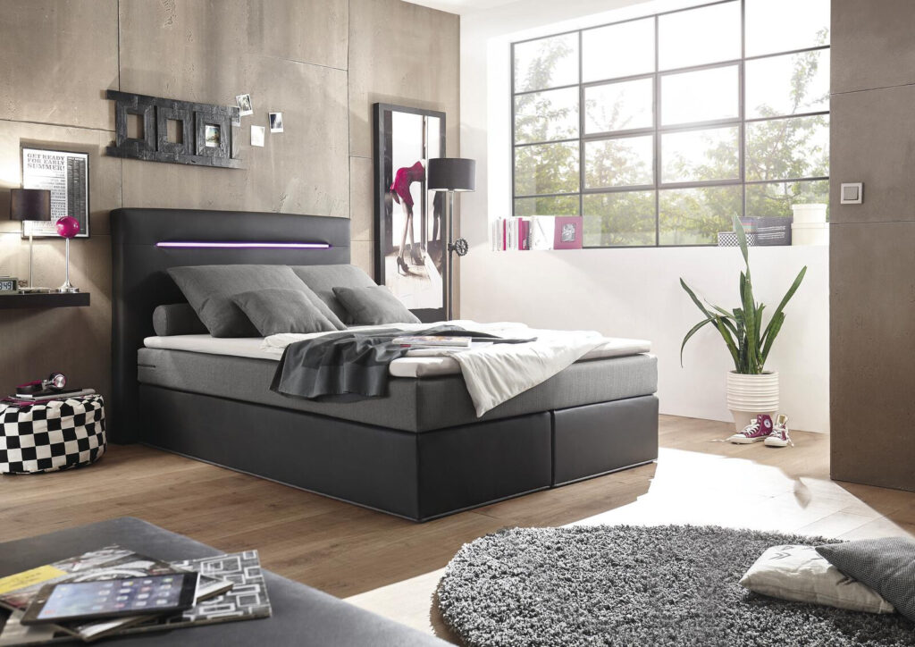 Modernes, grau gepolstertes Plattformbett mit LED-Kopfteilbeleuchtung in einem stilvollen Schlafzimmer.