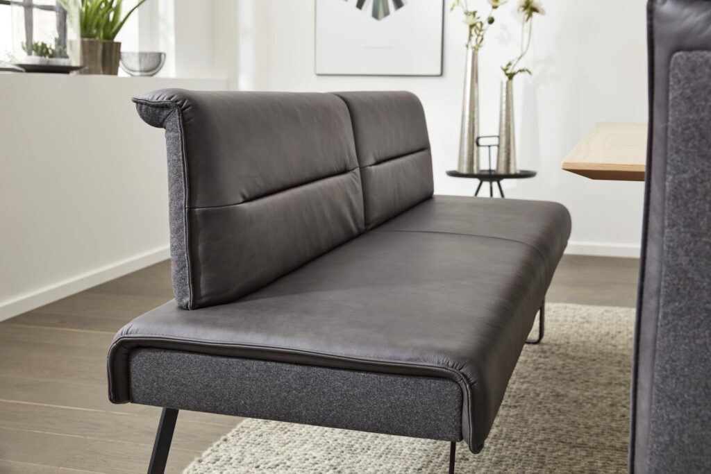 Nahaufnahme einer dunkelbraunen Lederbank mit grauem Stoffbesatz, ideal für ein Esszimmer.