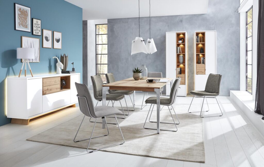 Modernes Esszimmer mit hellem Holztisch, grauen Stühlen und weißem Sideboard.