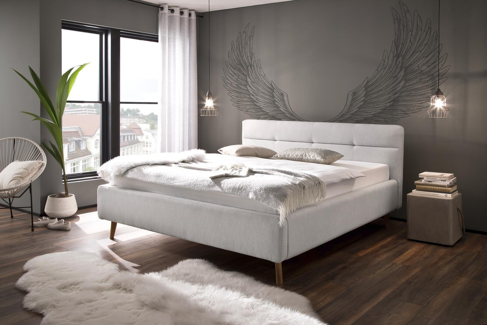 Modernes Schlafzimmer mit hellgrauem Polsterbett, flauschigem Teppich und großem Flügel-Wandbild.