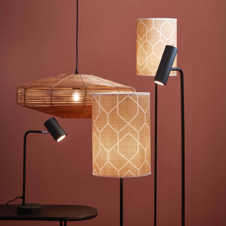 Drei stilvolle Lampen: eine gewebte Pendelleuchte, eine Stehlampe und eine Schreibtischlampe, alle mit Schirmen mit geometrischem Muster.