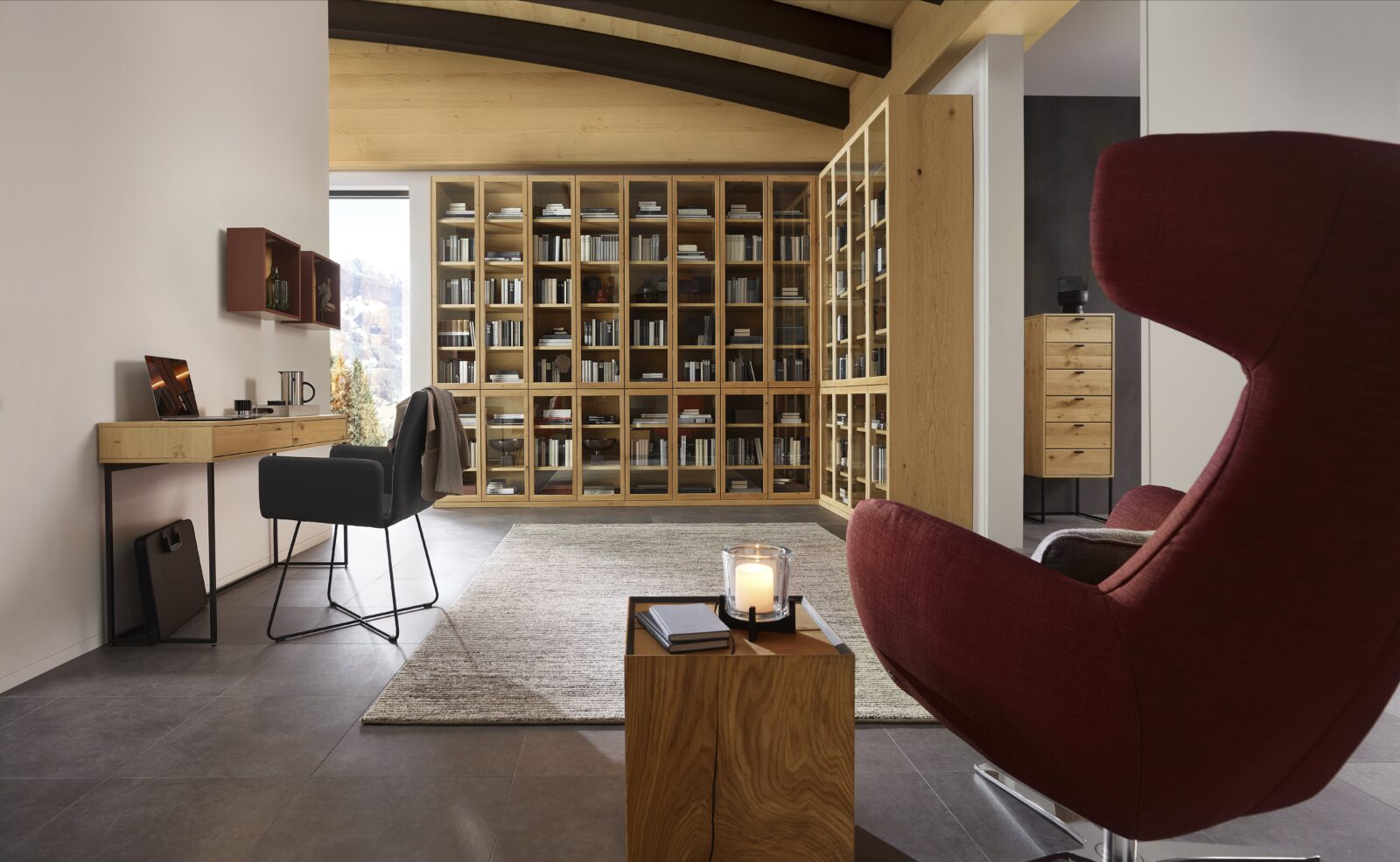 Modern home office with wooden bookcase and comfortable armchair. New Varianta Studio at Interliving Boer.