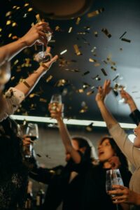Freunde feiern mit Champagner und Konfetti bei einer Veranstaltung im Oktober.