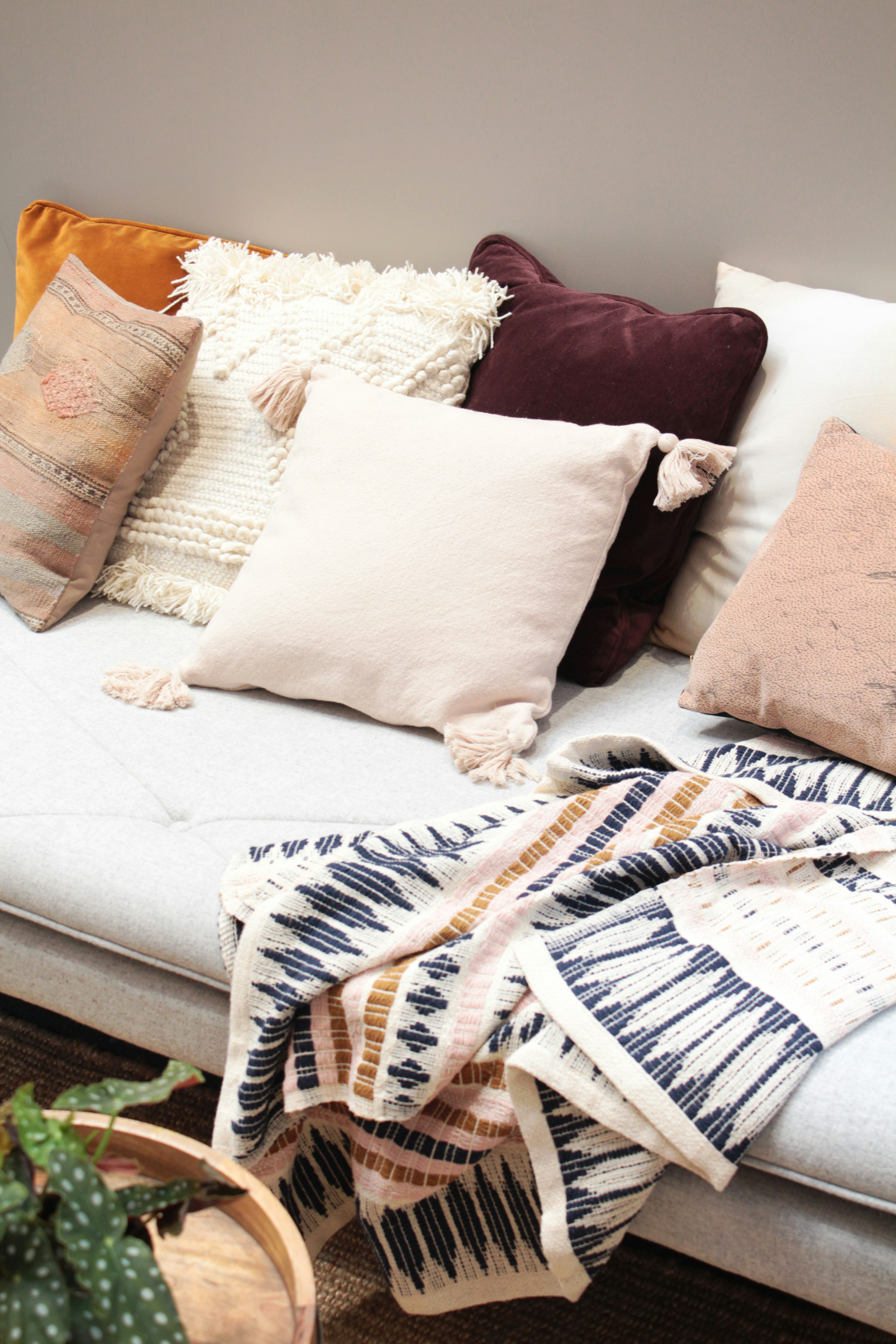 Cozy winter garden seating area with textured throw pillows and blanket. Prepare for cold weather with a warm and inviting space.