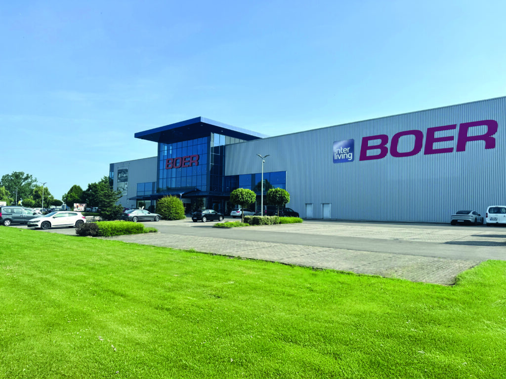 Großes Industriegebäude mit „BOER“-Beschilderung und geparkten Autos