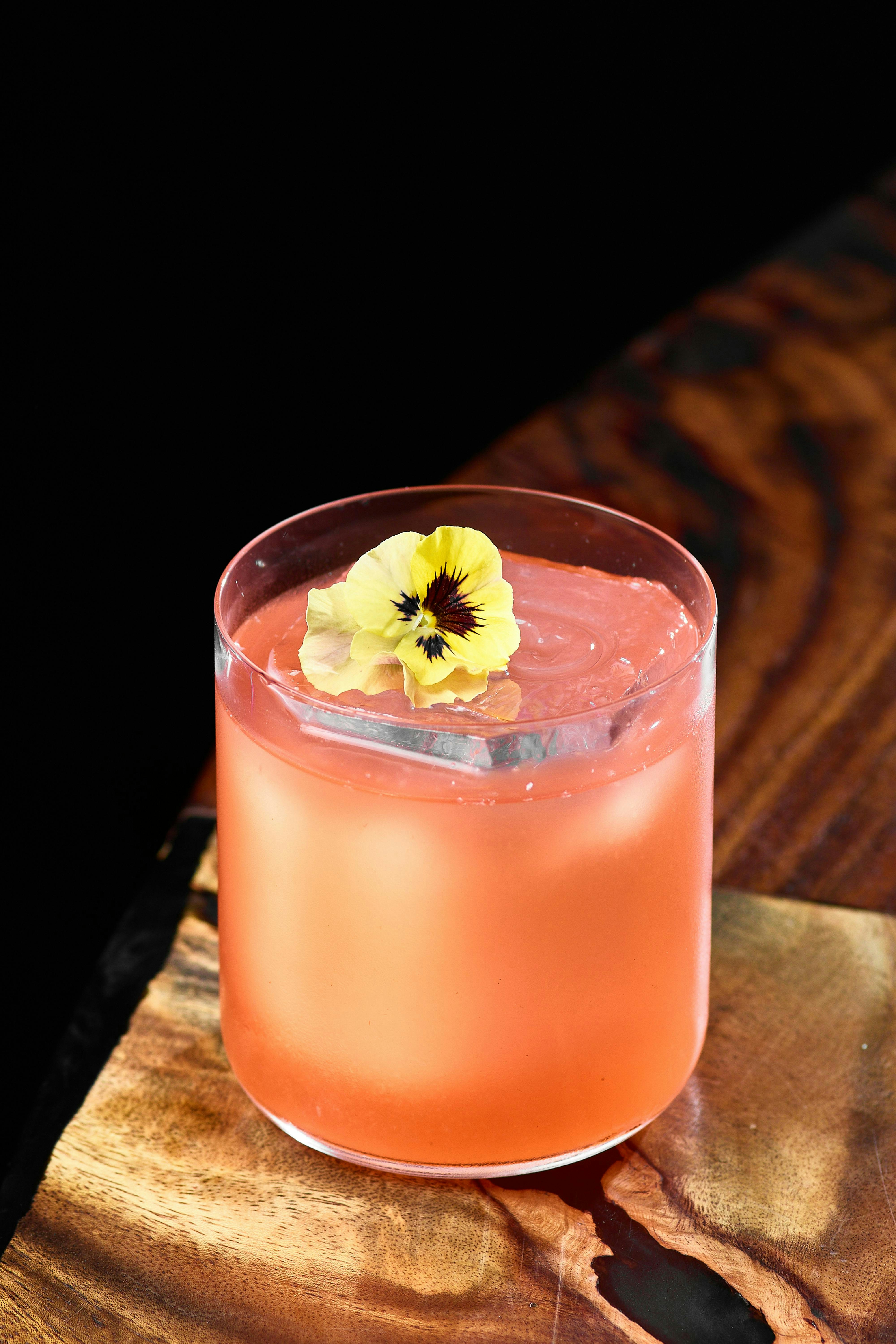 Erfrischender Sommerdrink im Glas mit Eis und Blume