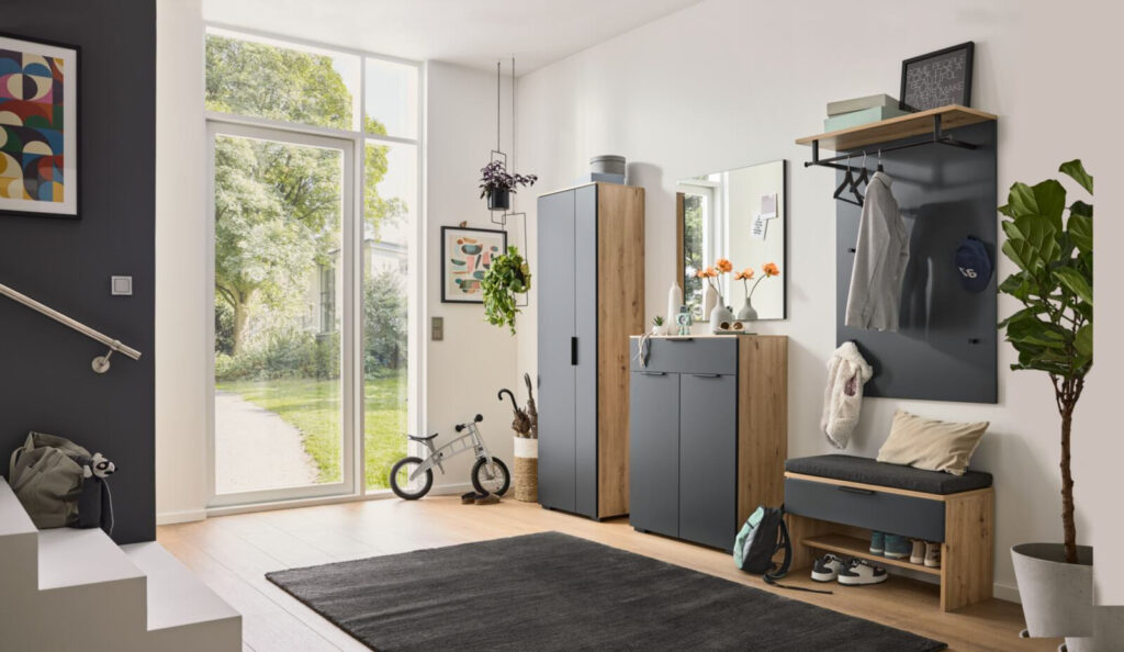 Moderner Eingangsbereich mit Garderobe, Spiegel und Sitzbank in Holz und Grau.