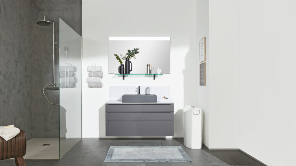 Modernes Badezimmer mit minimalistischem Design, grauen Möbeln und Dusche.