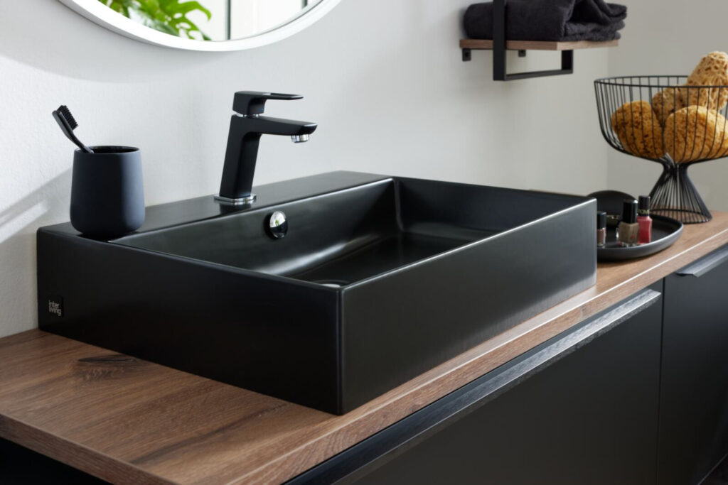 Schwarzes Aufsatzwaschbecken im modernen Badezimmer mit Holzarbeitsplatte.