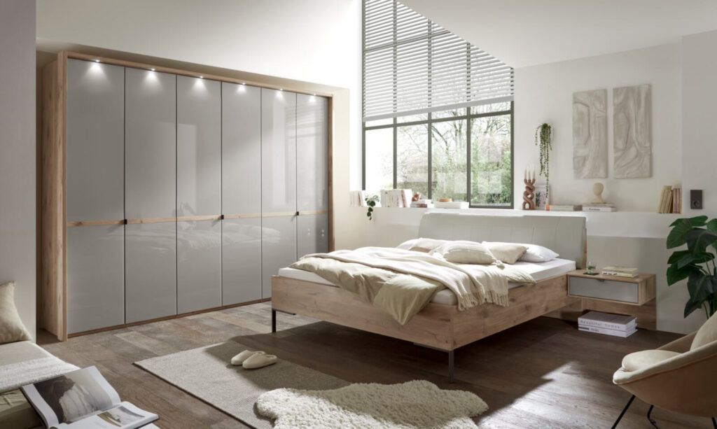 Modernes Schlafzimmer mit großem Kleiderschrank, Holzbett und Fenster.