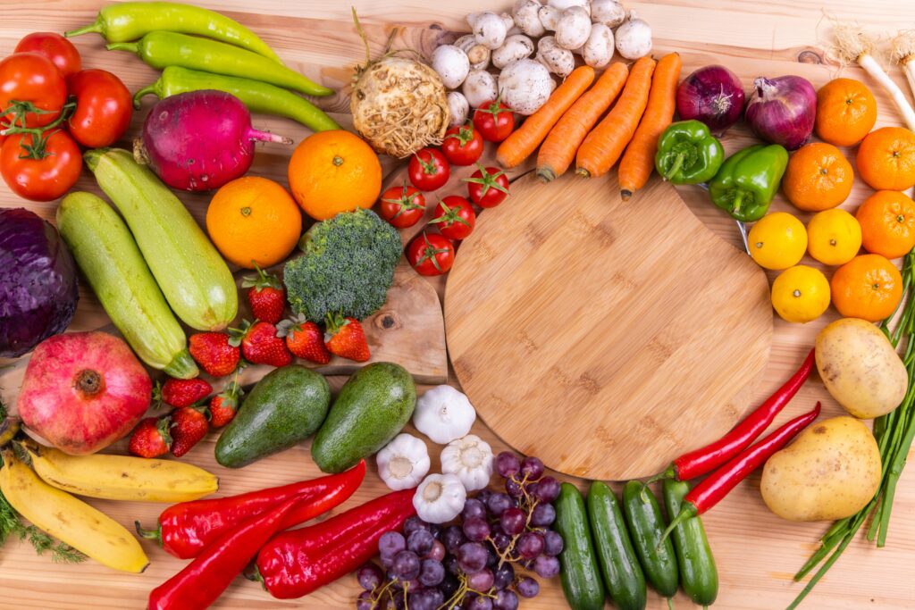 Vielfältiges Gemüse und Obst auf einem Holztisch, ideal zur Stärkung des Immunsystems.