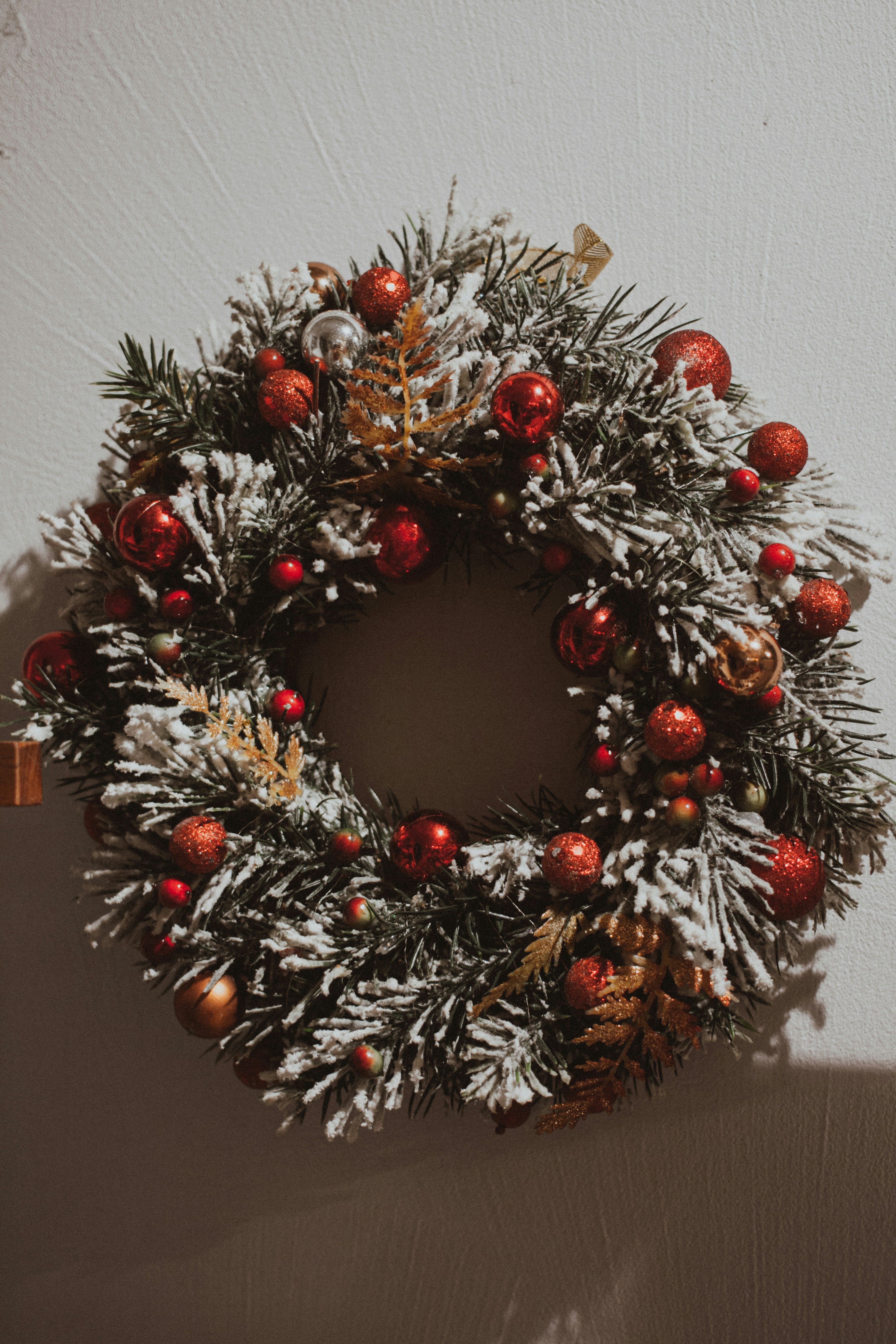 Festlicher Weihnachtskranz mit roten Kugeln und Schnee für stimmungsvolle Dekorationen.