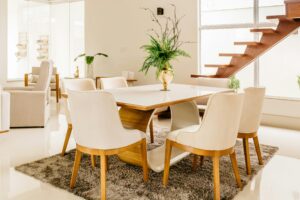 Elegantes Esszimmer mit modernem Tisch, Stühlen und Treppe. Neues Zuhause Interieur.