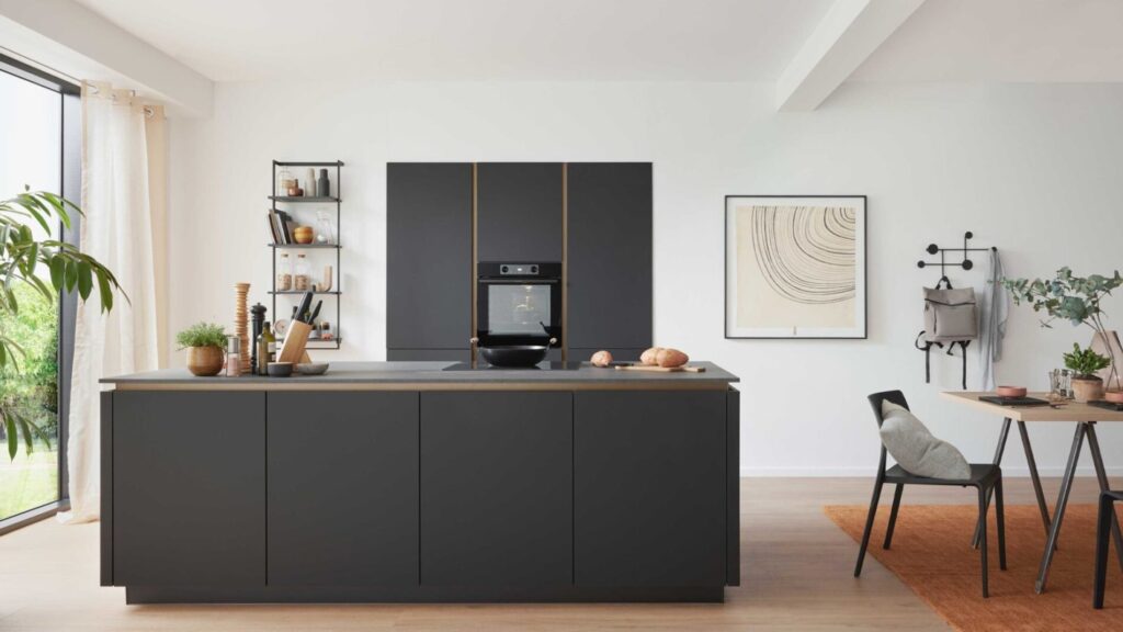 Moderne Küche mit schwarzen Schränken, Backofen und Esstisch Culineo Design Inselkueche Anthrazit