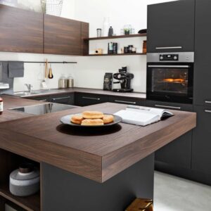 Moderne dunkle Küche mit Holzoberflächen und Frühstück