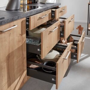 Moderne Holzküchenschränke mit offenen Schubladen, gefüllt mit Kochgeschirr.